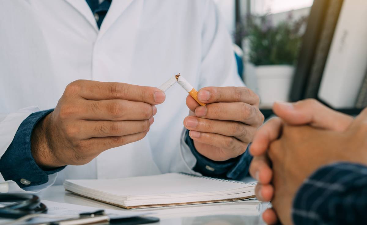 Dentist advising patient about dental implants failure from smoking during consultation.