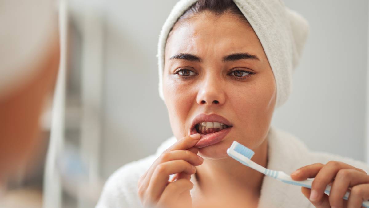 Young woman looking at her red bleeding gums