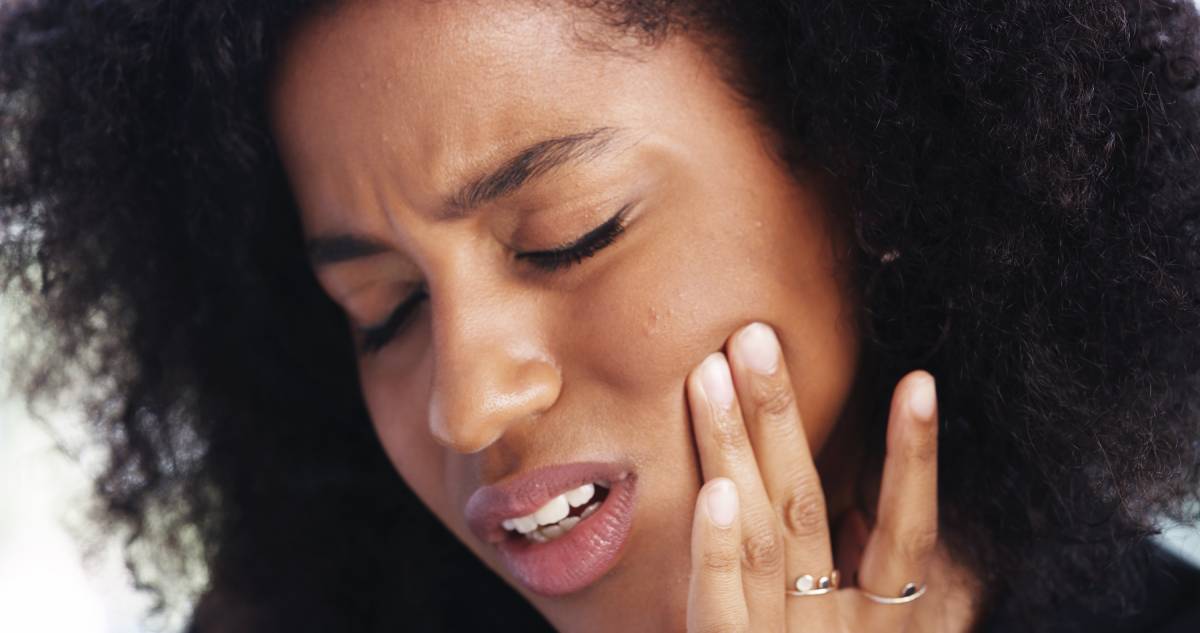 Woman touching jaw due to pain.